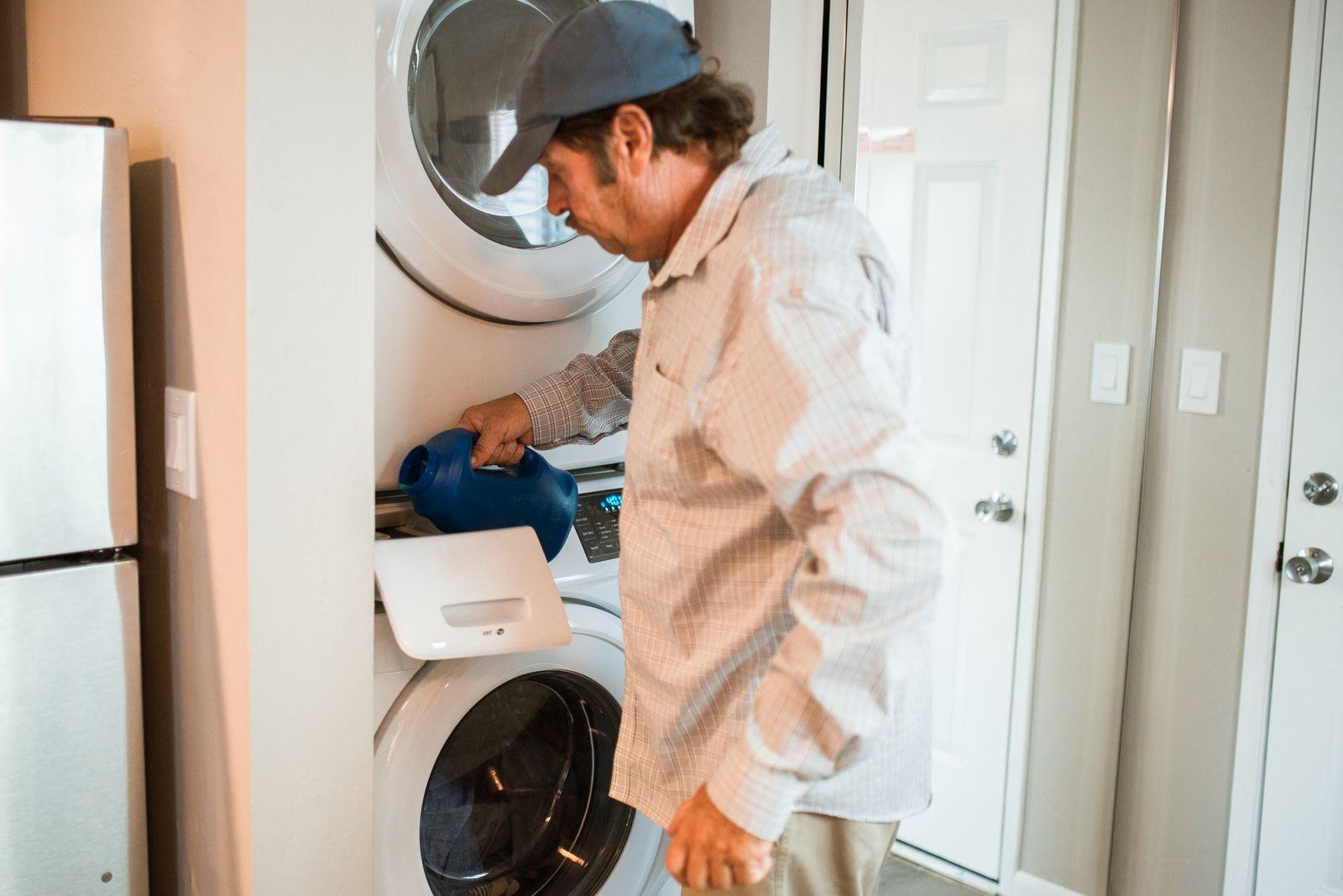 Detergent being poured into a front-load washing machine