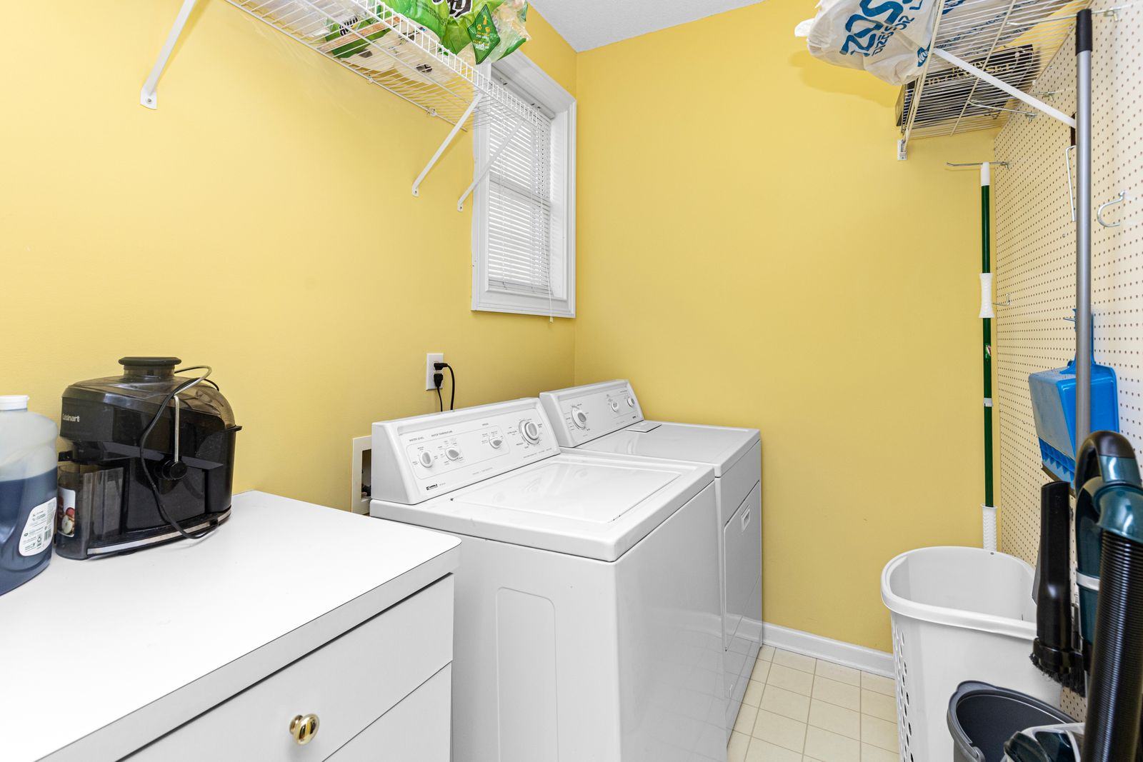 A bright, organized modern laundry room with a washer and dryer